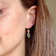 Load image into Gallery viewer, Close-up of a woman wearing gold earrings with green stones.