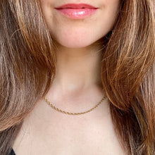 Load image into Gallery viewer, Close-up of a person wearing a gold necklace with long brown hair.