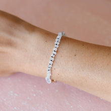 Load image into Gallery viewer, A delicate moonstone beaded bracelet worn on a person's wrist, shown against a soft pink background.