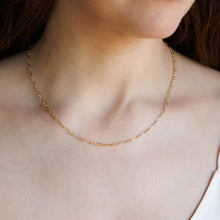 Load image into Gallery viewer, A close-up of a delicate gold chain necklace worn by a model in a white camisole top.