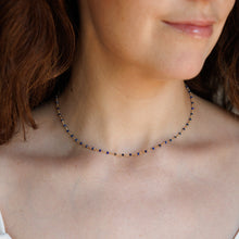 Load image into Gallery viewer, A close-up of a woman wearing a delicate beaded necklace with small blue beads.