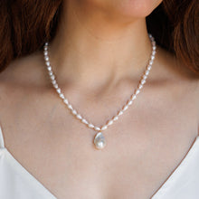 Load image into Gallery viewer, A close-up of a woman wearing a delicate white pearl necklace with a baroque white pearl pendant.