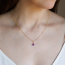 Load image into Gallery viewer, A close-up of a woman's neck and chest wearing a delicate gold chain necklace with a small teardrop-shaped purple amethyst pendant.